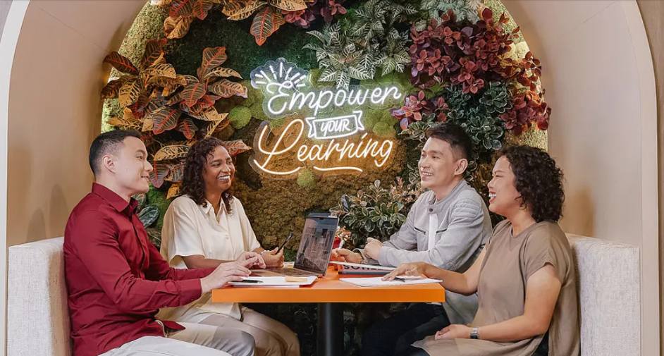 A group picture of 4 people having a discussion with the text "Empower your Learning"